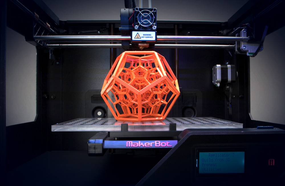 One of our 3D printers in action creating an intricate hyper-cube design.