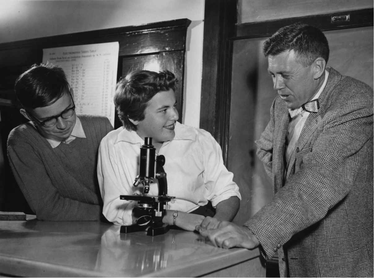Science classroom: Mr Len Chapman, science teacher, poses with two students (1956.)