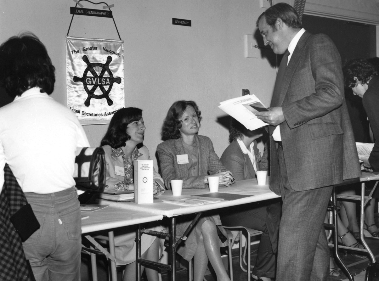 Bob Peacock, Coordinator of Business Education, speaking to Registrar at Secretaries Day Conference (1980.)