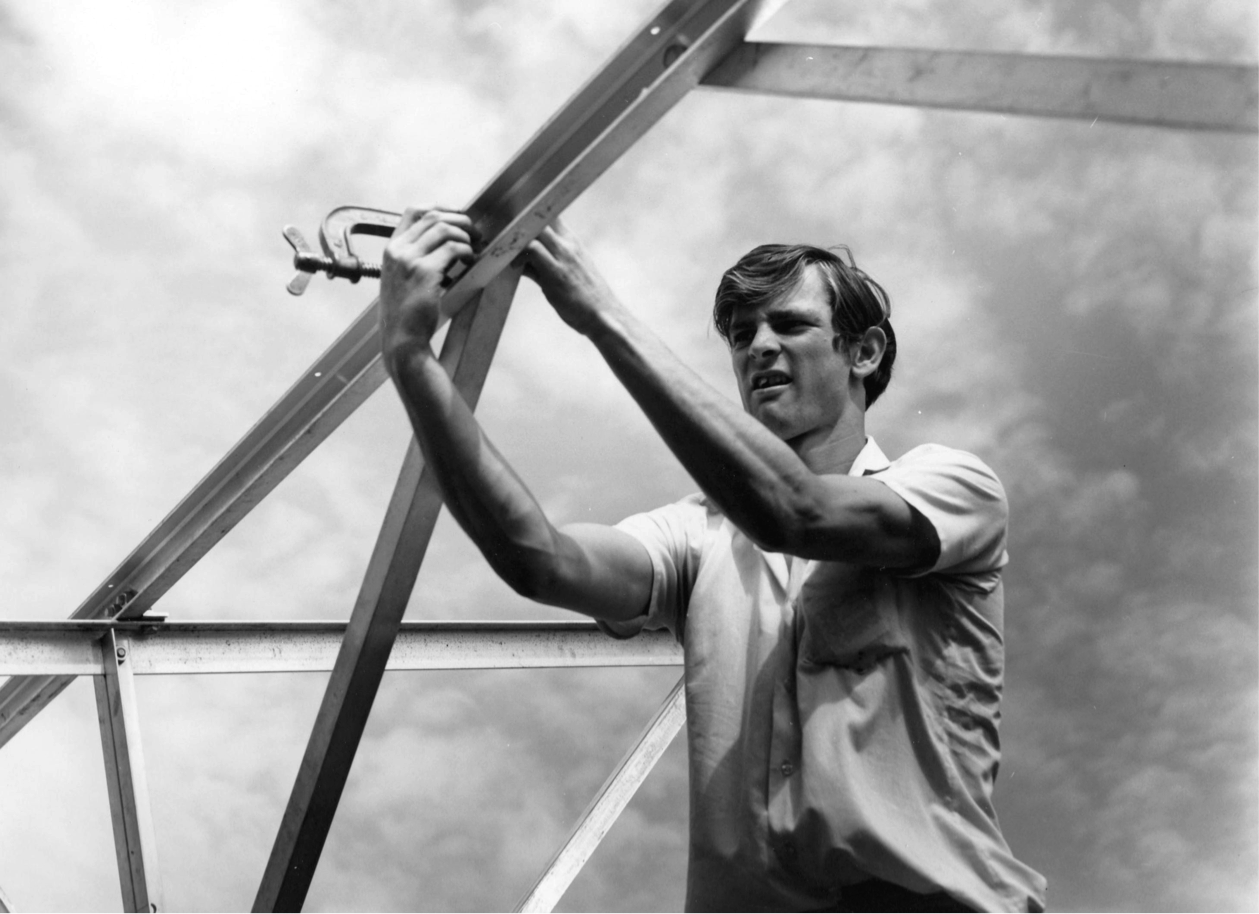 A student assembles the metal frame for a greenhouse on school property (1972.)